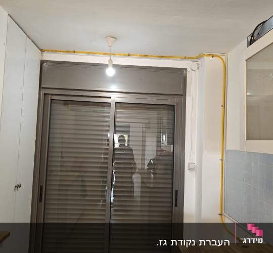 צינור גז צהוב מותקן על הקיר ליד חלון